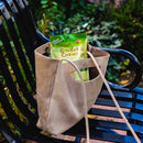 A package of Prince of Peace Ginger Candy (Chews) Mango in a tote bag on a chair in a garden.