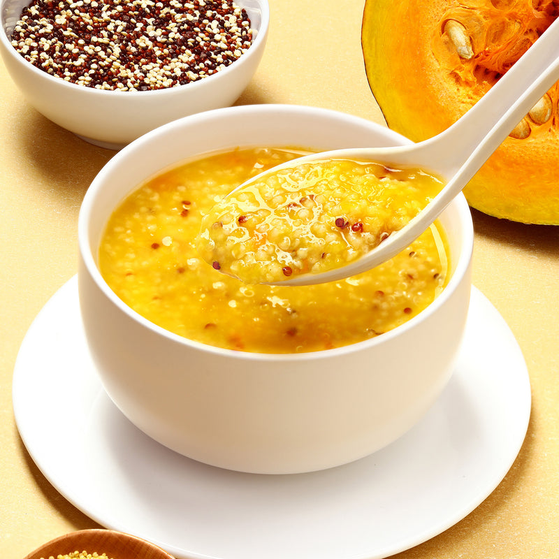 A bowl of Wing Wah Quinoa Pumpkin Millet Dessert with some ingredients in the back on a table.