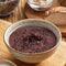 A bowl of Wing Wah Tangerine Peel Red Bean Dessert with some ingredients on a table.